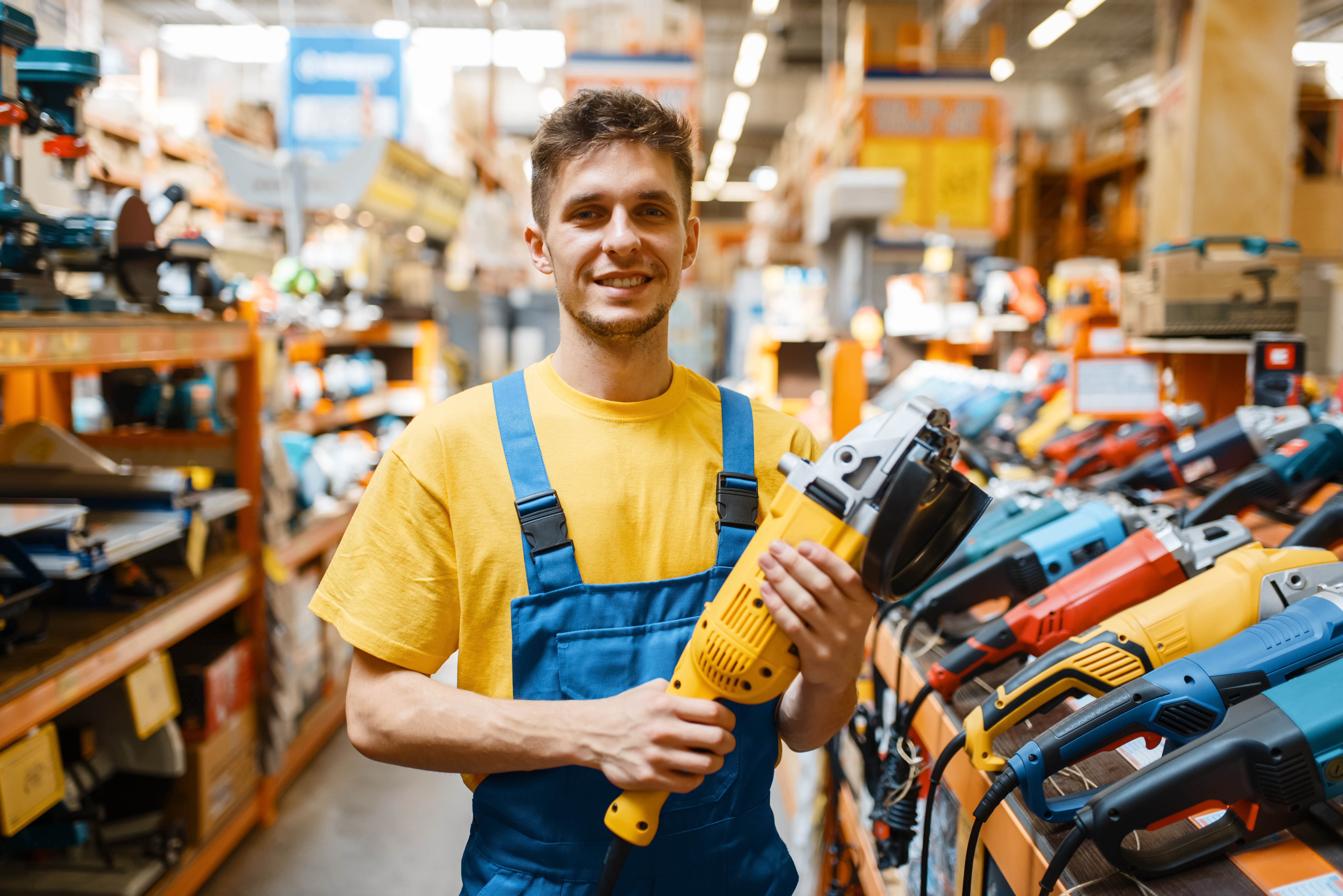 I work in a store. Мужчина выбор на полке инструмент. мужчина в строительном магазине. blue bg for construction store.